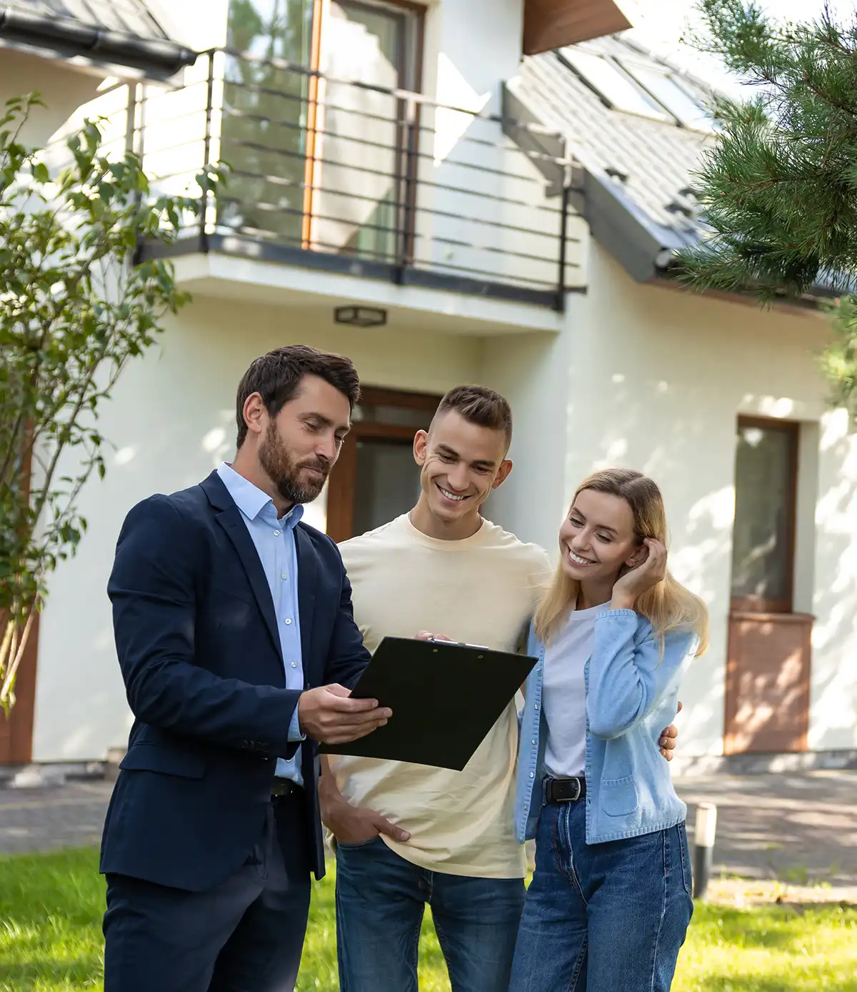 Berater überreicht einem Paar vor einem Wohnhaus ein Klemmbrett mit Dokumenten.